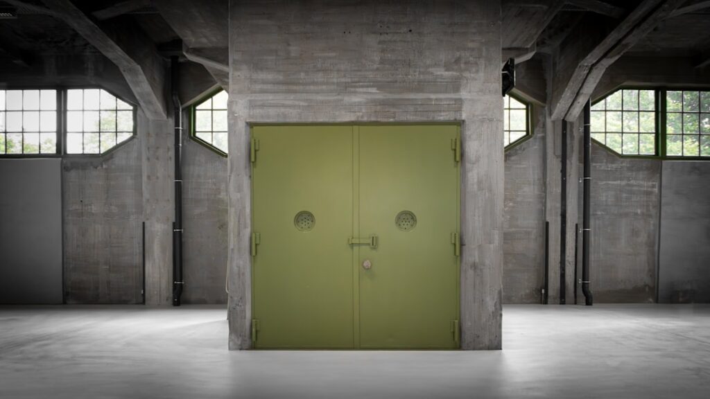 Stängd grön industridörr i lagerlokal med betongväggar