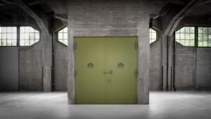 Stängd grön industridörr i lagerlokal med betongväggar